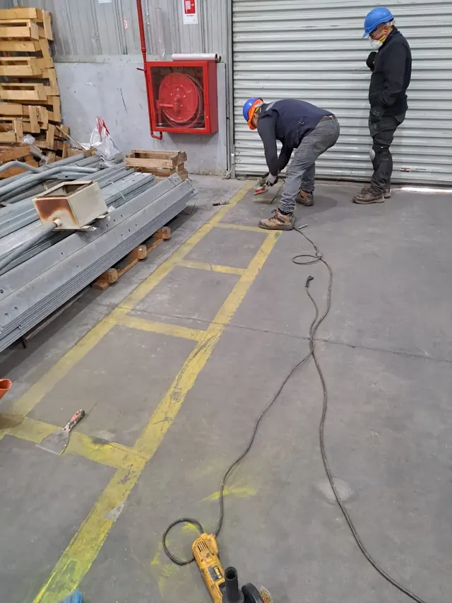 Registro del proyecto de renovación de demarcación de pisos realizado por Altos de Arauco Contratistas en las bodegas de Frontel, Coronel. Un trabajo orientado a mejorar la seguridad operacional y la visibilidad de las zonas de tránsito y carga, aplicando materiales de alta durabilidad y cumplimiento normativo. Demarcación de pisos renovada en bodega Frontel, Coronel – Altos de Arauco