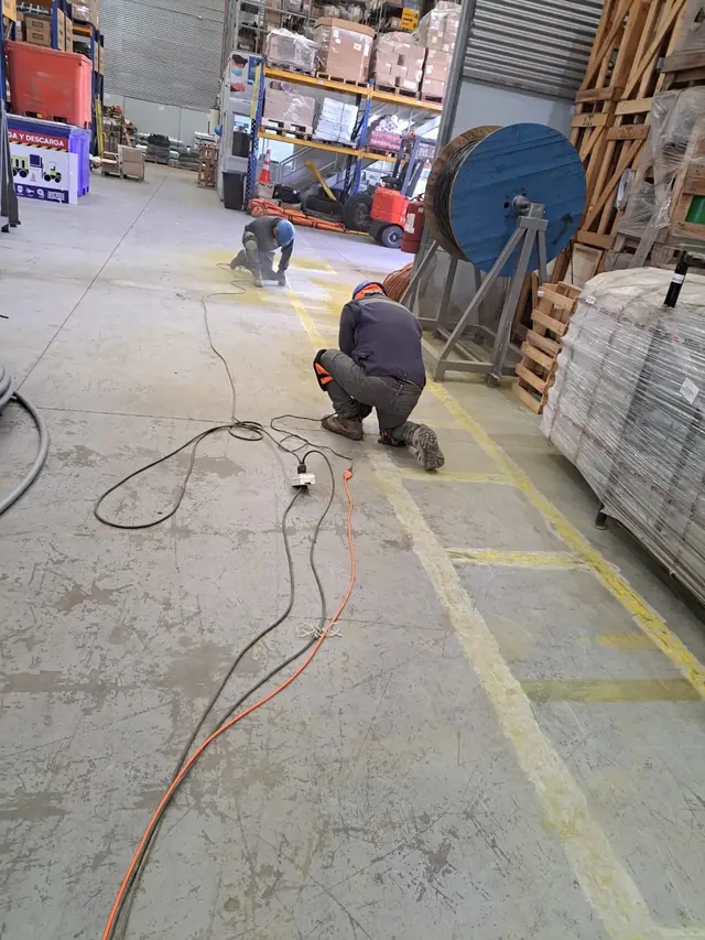 Captura del proceso de aplicación de pintura demarcatoria de alta resistencia para zonas operativas de Frontel, reforzando la señalización y los estándares de seguridad interna. Aplicación de pintura demarcatoria industrial en bodega Frontel