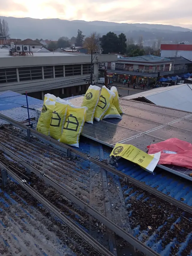 Bolsas de recolección de residuos y materiales tras limpieza completa de techumbre. Bolsas amarillas con residuos sobre cubierta tras mantenimiento.