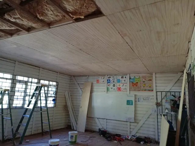 Aplicación de lana de vidrio en el cielo del aula para mejorar la eficiencia térmica en la Escuela Bellavista, Quilaco. Aislación térmica con lana de vidrio instalada en cielo de aula escolar.