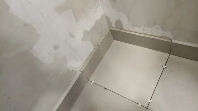 Reposición de porcelanato durante etapa de terminaciones. Proceso de instalación de porcelanato tras reparación por filtración de agua.