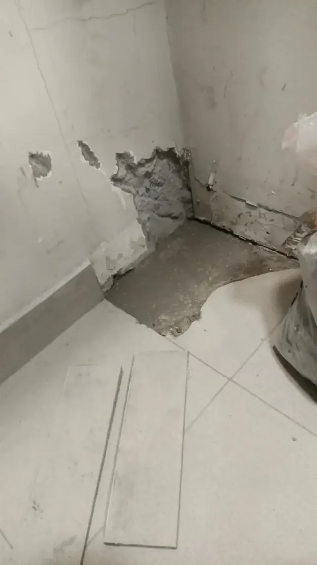 Daños iniciales detectados antes del mantenimiento de emergencia. Área de muro y piso deteriorada por humedad antes de la reparación.