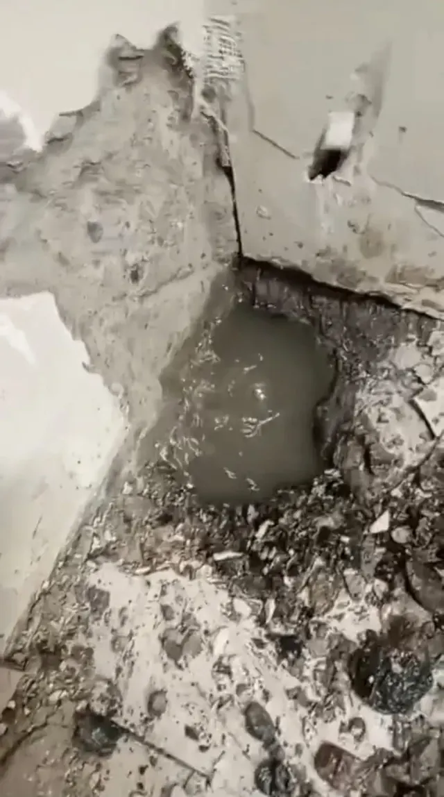 Resultado final del área intervenida después del mantenimiento. Esquina de muro y piso restaurada tras reparación de filtración en farmacia Cruz Verde.