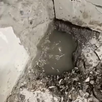 Esquina de muro y piso restaurada tras reparación de filtración en farmacia Cruz Verde.