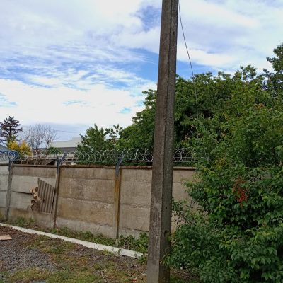 Muro perimetral con concertina nueva instalada y soportes reforzados.