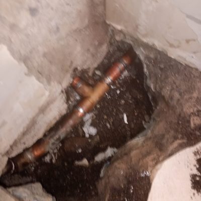 Cañería de cobre rota reparada durante mantenimiento de emergencia en farmacia Cruz Verde.