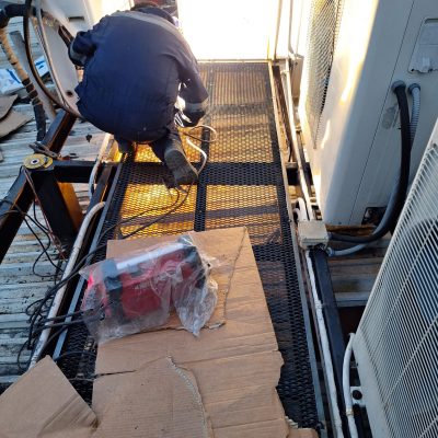 Pasarela metálica transitable instalada entre equipos de aire para mantenimiento seguro.
