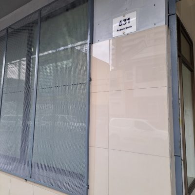 Operarios montando refuerzos de madera y metal para estructura metálica frontal.