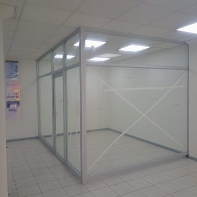 Oficina terminada con estructura de aluminio, paredes de vidrio y piso cerámico.