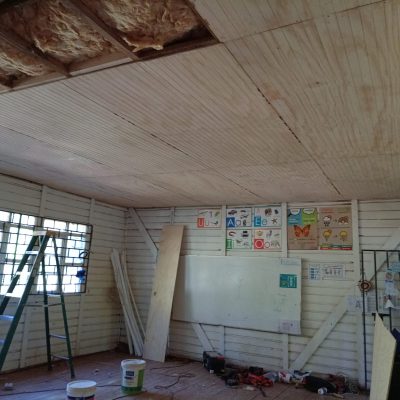 Aislación térmica con lana de vidrio instalada en cielo de aula escolar.