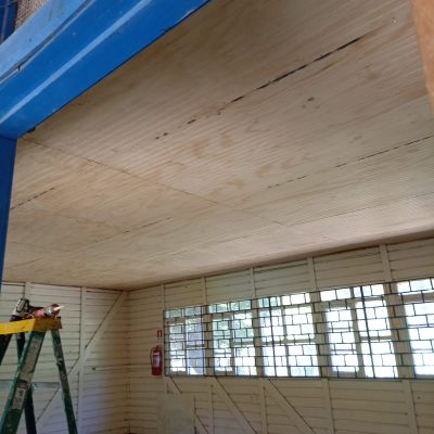 Cielo ranurado nuevo en proceso de instalación en aula escolar rural.