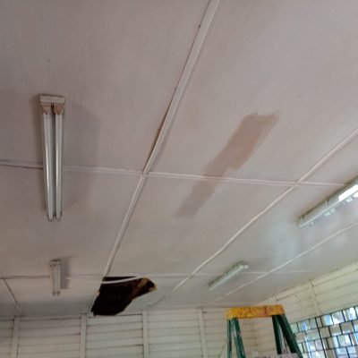 Cielo del aula con filtraciones y deterioro previo a trabajos de reparación.