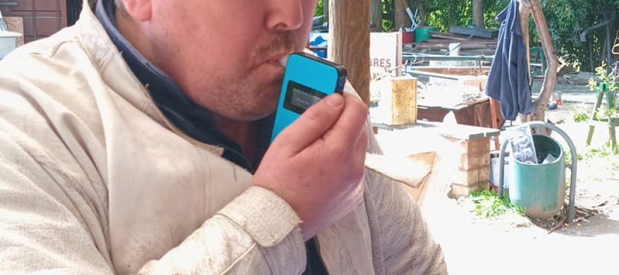 Trabajador realizando prueba de alcohol con dispositivo digital en obra.