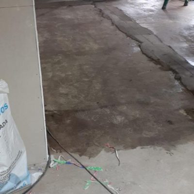 Trabajador revisando y nivelando el piso antes de instalar cerámica en obra.