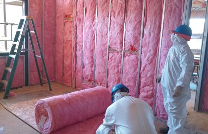 Personal técnico de Altos de Arauco utilizando equipos de protección personal durante instalación de aislación térmica.