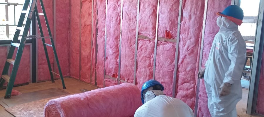 Personal técnico de Altos de Arauco utilizando equipos de protección personal durante instalación de aislación térmica.